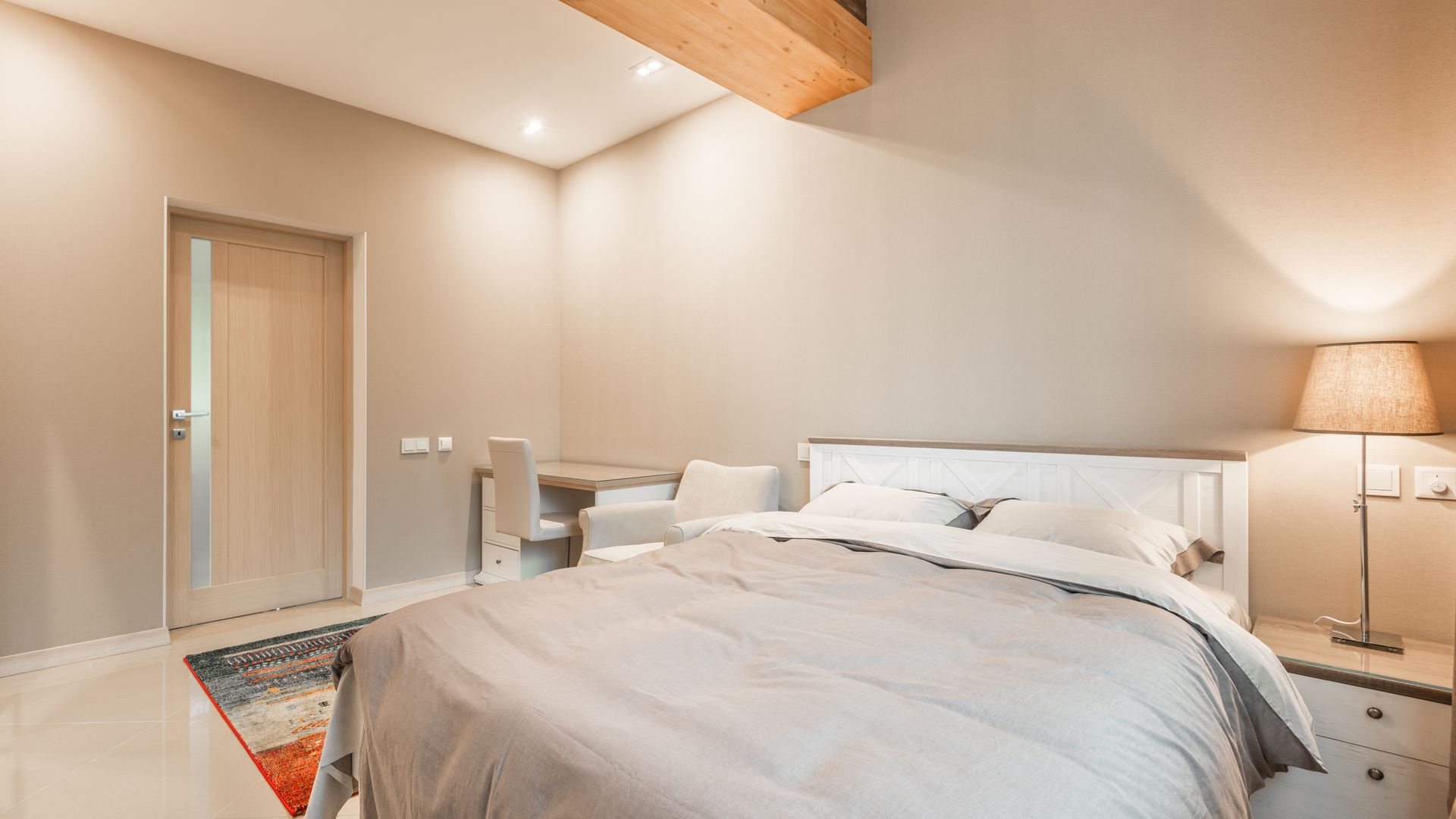 A bright, modern bedroom with a bed and desk
